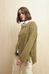 Sweater tejido color verde oliva con cruce irregular y botones a contraste.