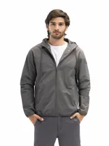 Campera rompevientos negra, liviana y funcional, con capucha ajustable, cierre frontal y dos bolsillos laterales con cierre. Posee forro interno de red para mejor ventilación.