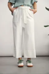 Pantalón blanco de corte ancho, con bolsillos laterales y lazo en la cintura.