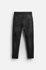 Pantalón de jean negro con corte skinny fit, cinco bolsillos, lavado con efecto roto y cierre frontal con cremallera y botón.