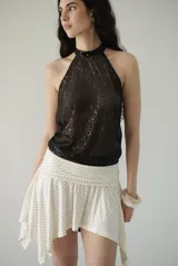 Top halter negro con lentejuelas, sin mangas y con cuello alto. Se ata al cuello.