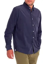 Camisa de hombre de manga larga, color azul marino, confeccionada en cotelé de algodón orgánico. Tiene cuello camisero, cierre con botones y bolsillo en el pecho.