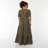Vestido largo color verde oliva, con cuello cruzado en V, mangas cortas abullonadas y falda larga escalonada.