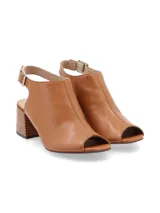 Sandalia peep toe color blanco hueso, confeccionada en cuero, con taco de madera y hebilla metálica.