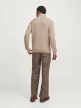 Sweater de punto color beige con cuello alto y cierre de cremallera parcial.