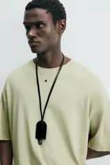 Camiseta verde oliva de corte holgado, cuello redondo y manga corta.
