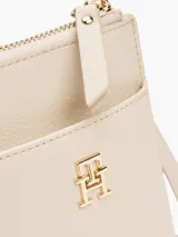 Cartera para móvil Tommy Hilfiger color beige con correa ajustable, cierre de cremallera, bolsillo exterior para el móvil, bolsillo interior con cremallera y múltiples ranuras interiores para tarjetas.