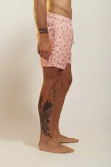 Bañador de hombre color rosa pálido con estampado de golondrinas oscuras. Presenta cintura elástica con cordón ajustable de color crudo y terminales turquesa.