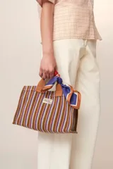 Mini bolso tote de algodón a rayas verticales marrones, azules y blancas, con doble asa de mano marrón y correa de hombro ajustable marrón.