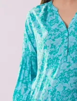 Blusa de gasa estampada con flores, marca Grand & Greene. Tiene cuello a la base, escote en V y abertura con botones.