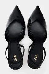 Zapato destalonado de charol negro con escote en pico, tira trasera ajustable y tacón fino.