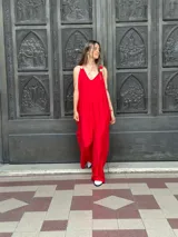 Mono de fiesta rojo con escote en V, breteles finos con apliques de strass y corte palazzo.