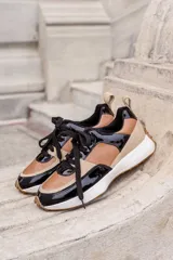 Championes de cuero color marrón, negro y beige, con cordones negros y suela blanca.