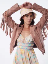 Chaqueta de cuero color marrón con corte entallado, cierre frontal asimétrico con cremallera, cuello con solapas de muesca y flecos decorativos en las mangas.