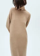 Vestido midi color beige de tejido de punto, con cuello redondo y manga larga.