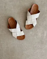 Sandalias bajas de cuero negro con tiras anchas cruzadas y plantilla anatómica color camel.