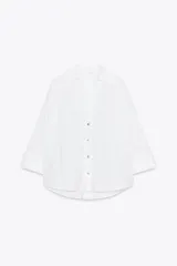 Camisa marrón de popelina con cuello solapa, escote en pico, cierre frontal con botones y mangas anchas con puños.