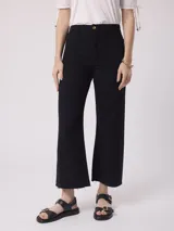 Pantalón de jean negro, tiro alto y pierna ancha con terminación desflecada.