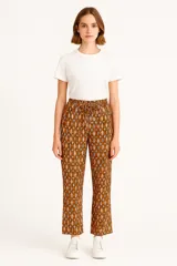 Pantalón babucha marrón con estampado floral en tonos beige, con cintura elástica ajustable con cordón.