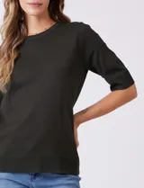 Buzo de punto fino color azul marino, con cuello redondo y mangas cortas.