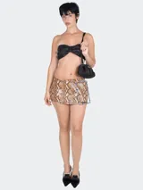 Minifalda con estampado de piel de serpiente y hebilla con pedrería.