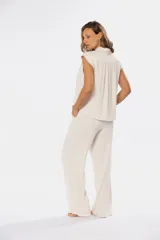 Pantalón de lino color beige con media cintura elastizada, bolsillos laterales y bolsillos decorativos en la parte trasera.