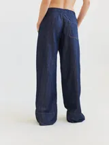 Pantalón ancho de jean con cintura elástica, corte holgado desde la cadera hasta el tobillo, diseñado para un look relajado y cómodo.