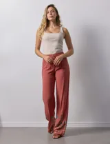 Pantalón de rayón color ladrillo, de corte palazzo, con pretina elastizada tipo smock y bordados florales en el ruedo.