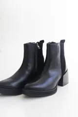 Botas negras de cuero con pulsera de tachas removible y taco de 6 cm.