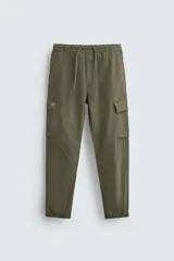 Pantalón cargo slim fit negro con cintura elástica ajustable con cordón, bolsillos frontales, traseros y laterales con solapa. Bajo con puño elástico.