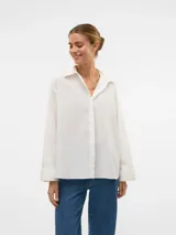 Camisa blanca oversize de manga larga con cuello clásico, puños abotonados y cierre frontal de botones.