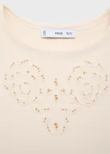 Vestido corto color crema, sin mangas, con cuello redondo y detalles calados en el cuello y ruedo.