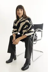 Sweater de punto con cuello alto y manga corta, con estampado de cebra en blanco y negro.