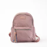 Mochila rosa de tela con cierre superior y bolsillo frontal con cierre. Tiene correas ajustables y un llavero decorativo.