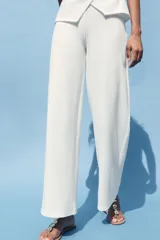 Pantalón de tiro medio color marrón claro, con cintura elástica y tejido con textura.