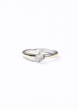 Anillo de estilo cintillo con cuerpo bicolor: banda exterior en tono dorado (doublé de oro) y banda interior en tono plateado (Plata 925). Engaste central de seis puntas que sujeta una piedra de zirconia redonda y facetada.