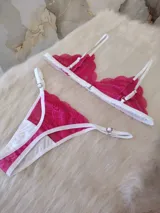 Conjunto de lencería fucsia de encaje floral, compuesto por un corpiño triangular sin aro y una tanga con tiras finas blancas.