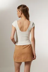 Top blanco de manga corta, ajustado al cuerpo y con escote profundo en V.