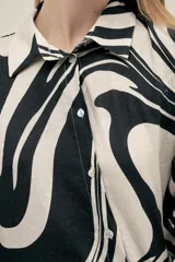 Camisa de manga larga con estampado abstracto en blanco y negro, de corte holgado.