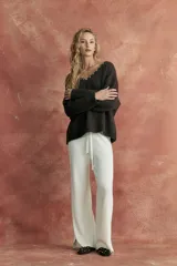 Pantalón de tejido de punto color crudo, de corte palazzo y cintura con cordón ajustable.