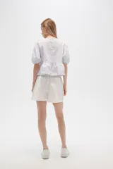 Short de algodón color blanco, de corte holgado y tiro alto, con cintura elástica y dobladillo en la botamanga.