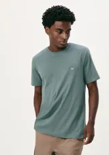 Camiseta verde de corte clásico, con cuello redondo y manga corta. Presenta un pequeño logo bordado en el pecho.