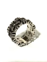 Anillo plateado con diseño de cruces y la inscripción "Chrome".