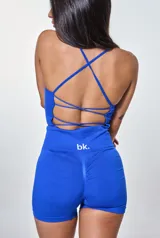 Conjunto deportivo azul eléctrico, compuesto por un top corto con tirantes finos y logo 'bk.' en el frente, y un short ajustado de tiro alto.