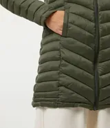 Campera puffer larga color verde militar, confeccionada en poliamida con relleno de poliéster. Tiene capucha ajustable, cierre frontal con cremallera, cuello alto y bolsillos laterales.