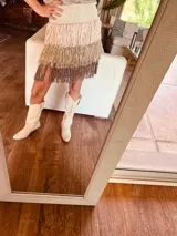 Minifalda tejida con cintura elástica y flecos en tres tonos: crudo, beige y marrón.