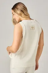 Chaleco de punto calado color blanco, con cuello redondo y sisas anchas.