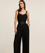 Mono de mujer color rojo oscuro (bordó), de corte recto y pierna ancha, con escote corazón y tirantes anchos con elástico. Presenta pliegues frontales que caen rectos hasta el ruedo.