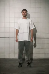 Remera blanca de algodón con cuello redondo y estampado con la frase "Good for nothing new collection est. 2001 el pinar city" y un pato con una botella de alcohol.