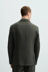 Blazer azul marino de lino con corte regular fit, cuello con solapas de muesca, manga larga con puños abotonados, bolsillo de vivo en el pecho, bolsillos de solapa en la cadera, bolsillo interior, aberturas en la espalda y cierre frontal de botonadura.